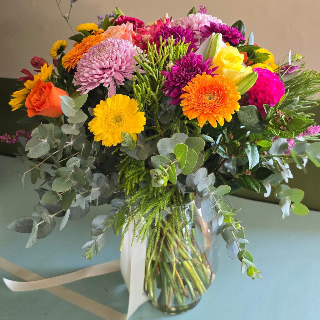 Seasonal selection of brightly colored flowers in a glass vase